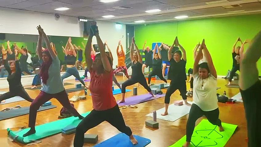 A full Hatha Yoga class holding a standing pose